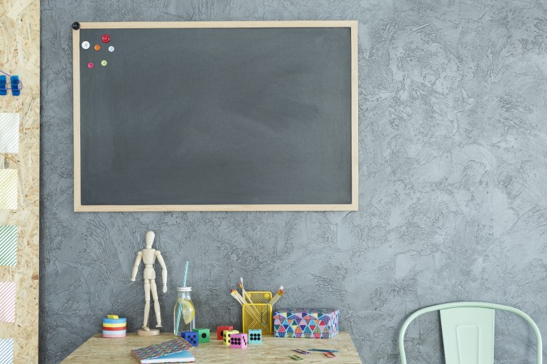 Gray home office with blackboard, wood desk and chair