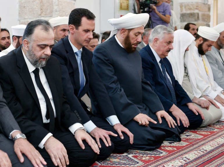 A handout picture released by the official Syrian Arab News Agency (SANA) on June 25, 2017, shows Syrian President Bashar al-Assad (2nd-L), Syria's Grand Mufti Ahmad Badreddin Hassoun (3rd-L), and Minister of Awqaf (Religious Endowments ) Mohammad Abdul-Sattar al-Sayyed (L) attending prayers to mark Eid al-Fitr, the end of the Muslim holy month of Ramadan, at al-Nuri mosque in the central province of Hama. (Photo by SANA / AFP) / == RESTRICTED TO EDITORIAL USE - MANDATORY CREDIT "AFP PHOTO / HO / SANA" - NO MARKETING NO ADVERTISING CAMPAIGNS - DISTRIBUTED AS A SERVICE TO CLIENTS == - == RESTRICTED TO EDITORIAL USE - MANDATORY CREDIT "AFP PHOTO / HO / SANA" - NO MARKETING NO ADVERTISING CAMPAIGNS - DISTRIBUTED AS A SERVICE TO CLIENTS == /