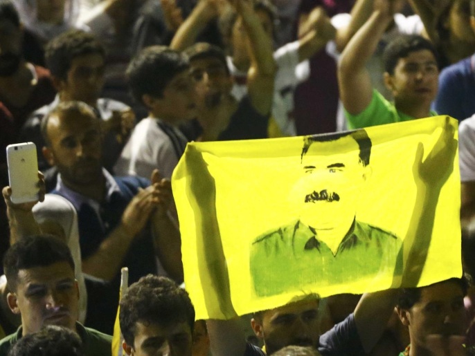 Supporters hold a flag with the image of Abdullah Ocalan, jailed leader of the Kurdistan Workers' Party (PKK) as they celebrate outside the pro-Kurdish Peoples' Democratic Party (HDP) headquarters in Diyarbakir, Turkey, June 7, 2015. Thousands of jubilant Kurds flooded the streets of Turkey's southeastern city of Diyarbakir on Sunday, setting off fireworks and waving flags as the pro-Kurdish opposition looked likely to enter parliament as a party for the first time. REUTERS/Osman Orsal