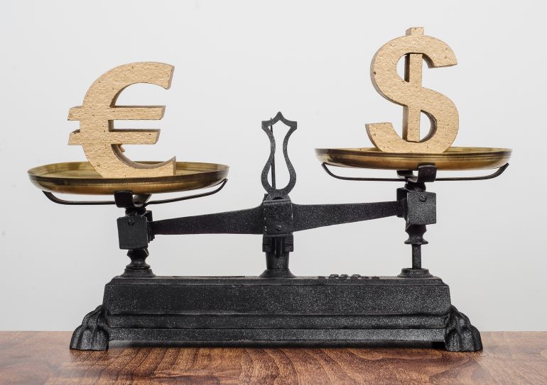 Exchange rate, Dollar higher than the Euro. Currency on antique balance scales.