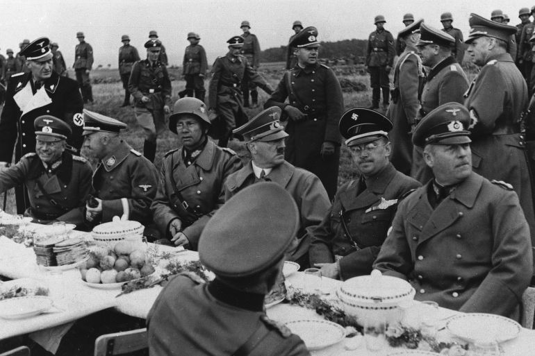 Adolf Hitler is surrounded by his aides, all of them high in the German Reich, during a field meal near Eger, Czechoslovakia, Oct. 3, 1938. The potatoes and pumpernickel bread in front of Der Fuehrer, a strict vegetarian, and the unbroken line of guards stationed out of hearing behind the table. From left, (first man unidentified) Heinrich Himmler, Gestapo chief; General W. Von Reichnau, commander of the Army Corps which occupied the Third Zone; Hitler; Konrad Heinlein, Czech Nazi leader; and Gen. Wilhelm Keitel, chief of the high command of the German Army. (AP Photo)