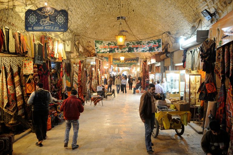 People walk through the Al-Madina Souq market in Aleppo in this March 3, 2011 file photo. Hundreds of shops were burning in the ancient covered market in Aleppo on September 29, 2012 as fighting between rebels and state forces in Syria's largest city threatened to destroy a UNESCO world heritage site. Aleppo's Old City is one of several locations in Syria declared world heritage sites by UNESCO, the United Nations cultural agency, that are now at risk from the fighting. Picture taken March 3, 2011. REUTERS/Fabian Bimmer/Files (SYRIA - Tags: TRAVEL CIVIL UNREST)