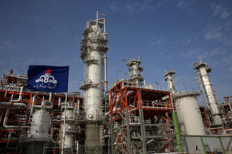 This Saturday, March 16, 2019 photo, shows a natural gas refinery at the South Pars gas field on the northern coast of the Persian Gulf, in Asaluyeh, Iran. Iran's President Hassan Rouhani on Sunday inaugurated a new phase in the development of the South Pars natural gas field. Iran says the development will allow Iran to overtake Qatar in the production of natural gas. The two countries are among the biggest gas producers in the world, and share the South Pars gas field. The flag of Iran's Pars Oil and Gas Company waves at left. (AP Photo/Vahid Salemi)