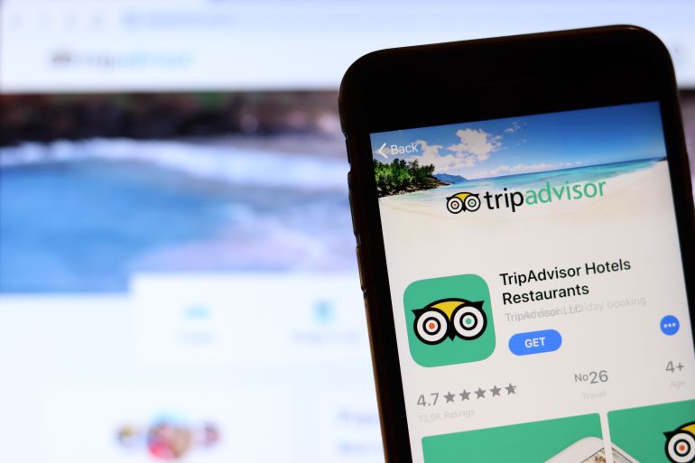 Los Angeles, California, USA - 26 November 2019: TripAdvisor icon on phone screen with logo on blurry background, Illustrative Editorial