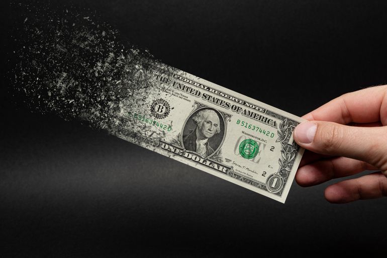 Inflation, dollar hyperinflation with black background. One dollar bill is sprayed in the hand of a man on a black background. The concept of decreasing purchasing power, inflation.