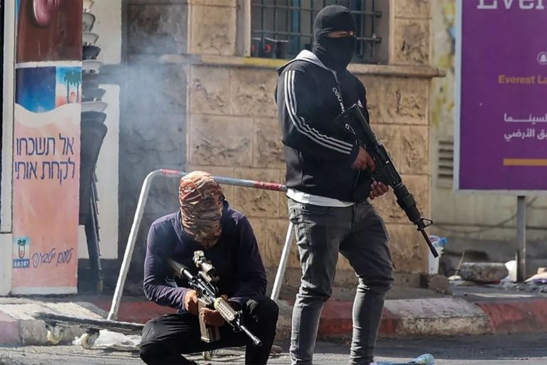 Palestinian armed militants take up position during a confrontation with Israeli army in the occupied West Bank city of Jenin on July 3, 2023. The Israeli army said it had launched drone strikes in Jenin as part of an "extensive counterterrorism effort" that the Palestinian health ministry said killed four residents. (Photo by Jaafar ASHTIYEH / AFP
