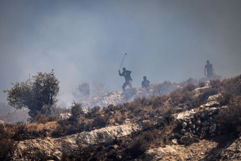 Masked Israeli settlers hurl rocks at Palestinians from hilltop in the village of Sinjil, in the occupied West Bank on July 4, 2025.