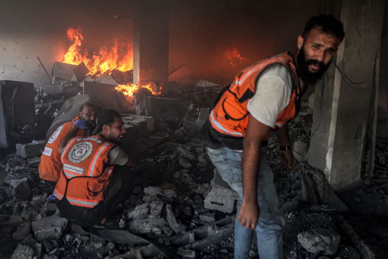 TOPSHOT - Palestinian civil defence try to extinguish a fire at a building hit by an Israeli strike in Gaza City in the central Gaza Strip, on July 2, 2025, amid the ongoing conflict between Israel and the Palestinian Hamas militant group.