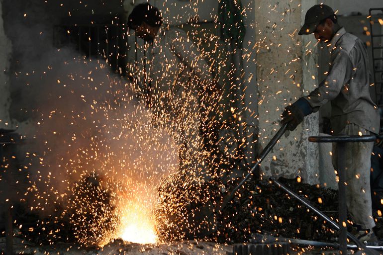 A man works in a steel factory in Lahore April 29, 2009. REUTERS/Mohsin Raza (PAKISTAN SOCIETY)