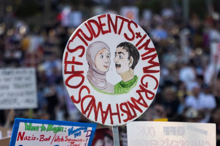 A protester holds a sign reading "hands off students and immigrants" during the nationwide "Hands Off!" protest against US President Donald Trump and his advisor, Tesla CEO Elon Musk, in downtown Los Angeles on April 5, 2025. Protesters flooded the streets of several major US cities on Saturday to oppose the divisive policies of President Donald Trump, in the largest demonstrations since his return to the White House. Opponents of the Republican president's policies -- from government staffing cuts to trade tariffs and eroding civil liberties -- rallied in Washington, New York, Houston, Los Angeles and Florida, among other locations. (Photo by ETIENNE LAURENT / AFP)