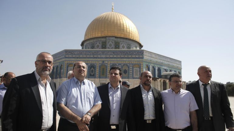 Israeli-Arab lawmakers from the Joint List of Arab parties (from L to R) lawyer Osama Saadi, Knesset member Ahmad Tibi, leader of the joint list of Arab parties Ayman Odeh, and political leaders Masud Ghanayem, Youssef Jabarin and Basel Ghattas pose for a photo in front of the Dome of the Rock at the Al-Aqsa Mosque compound, Islams third holiest site, in the Old City of Jerusalem on July 28, 2015. AFP PHOTO / AHMAD GHARABLI