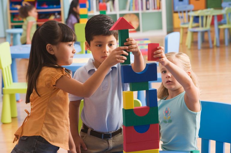 Children (4-7) playing with building block - stock photo